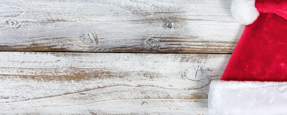 Christmas Santa Claus hat on rustic knotty wooden background