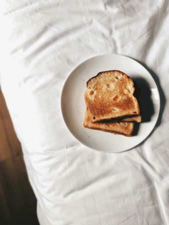 Toast with Butter on Plate in Bed Morning