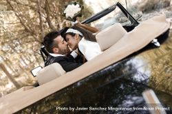 Newlyweds kissing in vintage car 431wx0