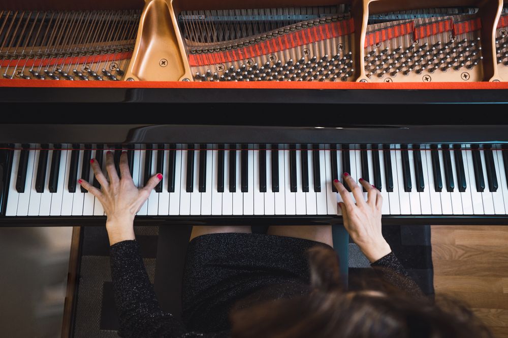 Top view of cropped hands playing the piano