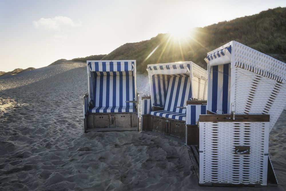 Three empty beach chairs in the shade