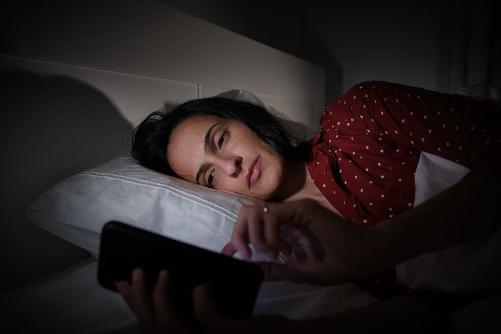 woman surfing smartphone at night time