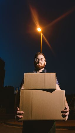 Courier delivering cardboard boxes in evening