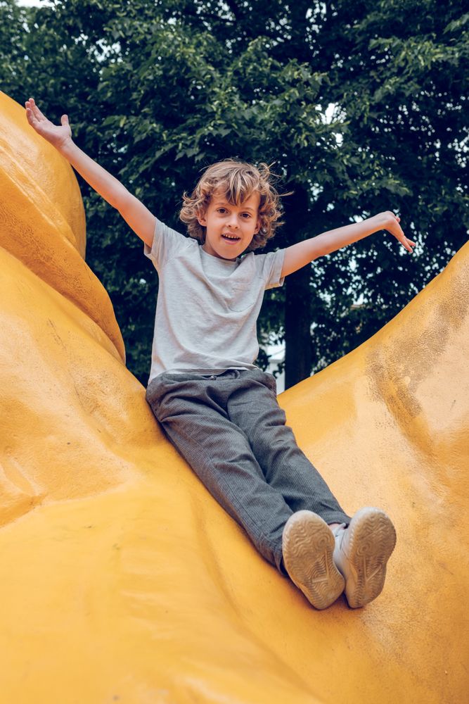 Cheerful boy sitting on yellow monument
