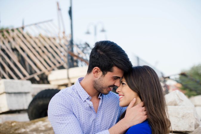 Loving couple hugging in abandoned building with metal fence