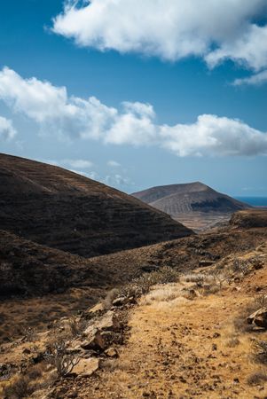 Two dry hills under a blue sunny sky
