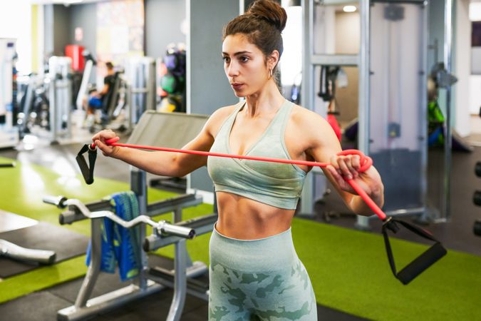 Athletic woman working out upper body with resistance bands