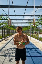 Strong young athlete putting on wrist straps