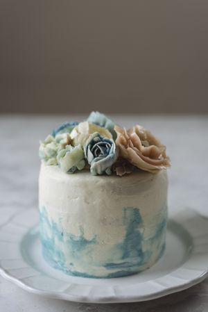 Buttercream flowers cake, blue and pastel peach colors