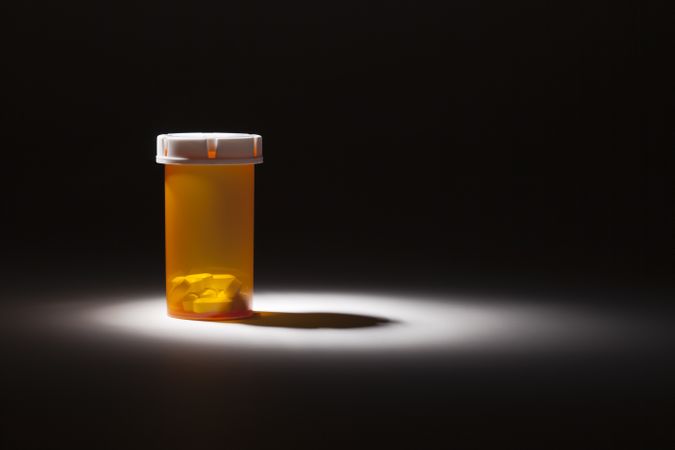 Medicine Bottle and Pills Under Spot Light