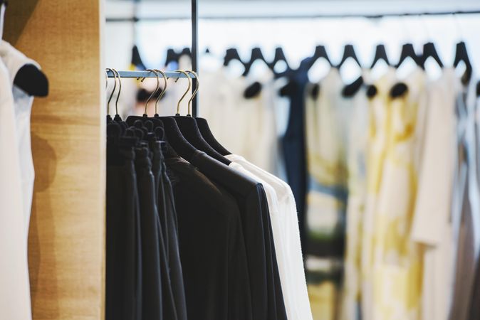 Clothes racks of dark and light outfits in fashion store