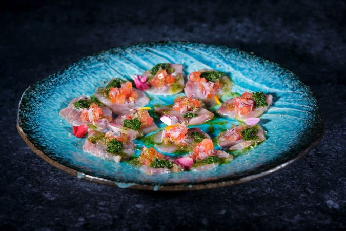 Plate with delicious fish dish on marble surface
