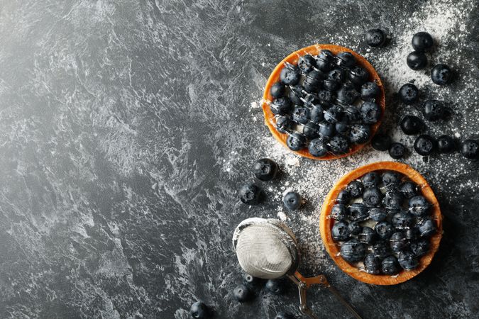 Concept of tasty lunch with blueberry pies on dark background