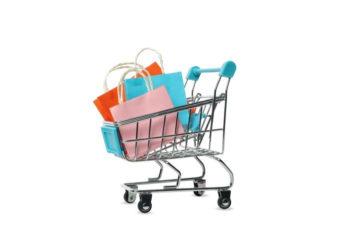 Shop cart with paper bags isolated on light background