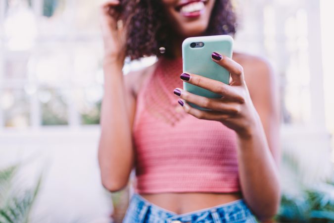 Young woman smiling while texting on a smartphone