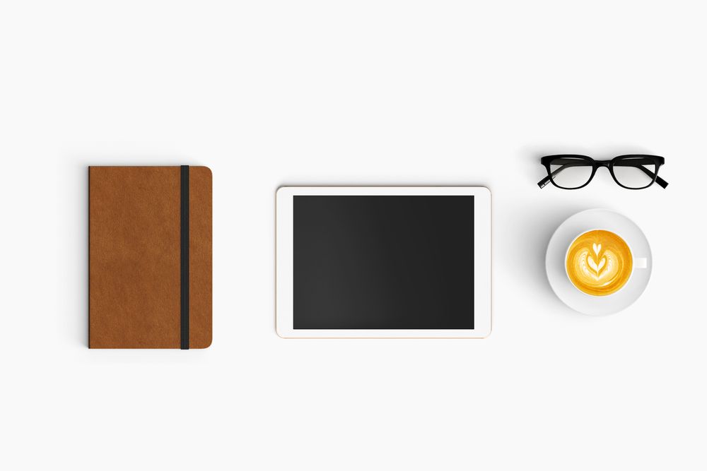 Modern workspace with coffee cup, notebook and tablet copy space