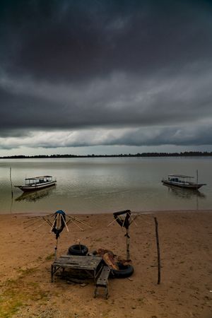 Boats on remote sandy beach in clouds
