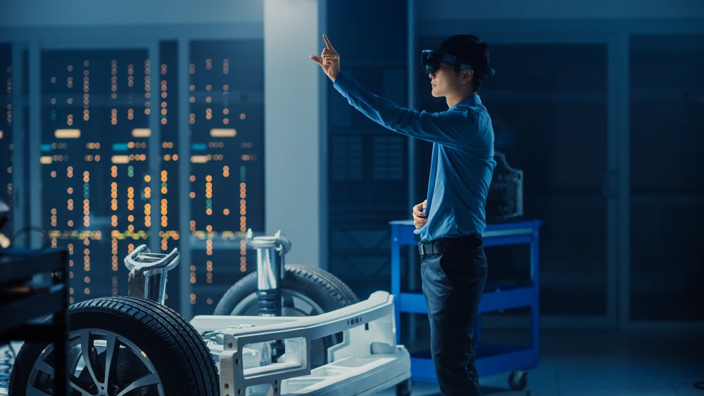 Automotive Engineer Working on Electric Car Chassis Platform, Using Augmented Reality Headset with Touching Gestures.