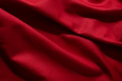 Close Up Crumpled wavy Red silky fabric background texture.