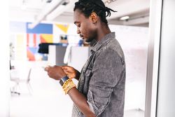 Young man checking his mobile device in a modern office