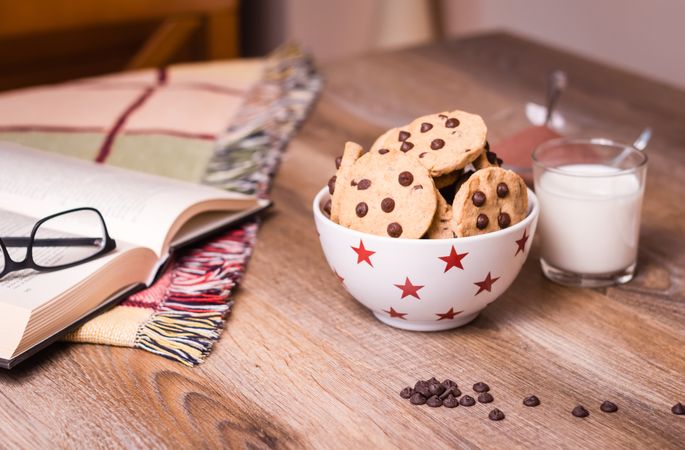 Chocolate chip cookies and milk on wood background