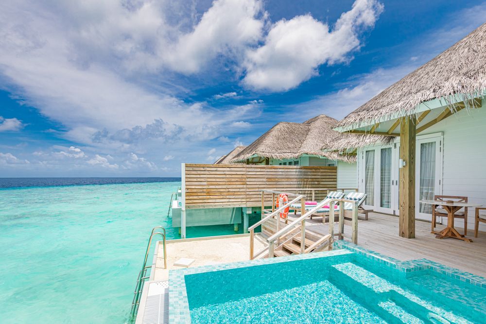 Patio of holiday villa with pool over looking a clear ocean