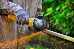 Man cutting a metal rod
