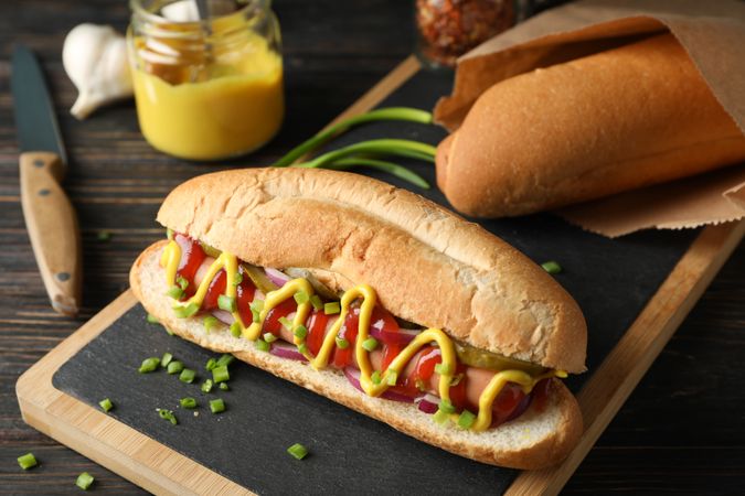 Tasty hot dog and ingredients on wooden background