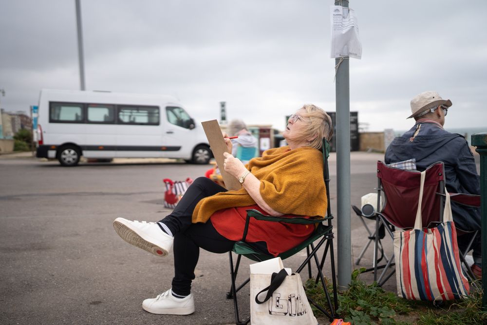 Mature woman sitting calmly outside drawing