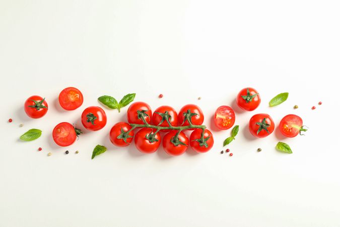 Flat lay composition with fresh cherry tomatoes, pepper and basil on plain background, space for text. Ripe vegetables