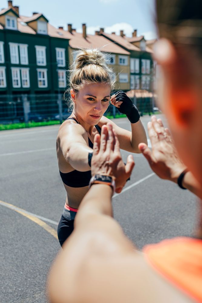 Sportswoman training boxing with her trainer