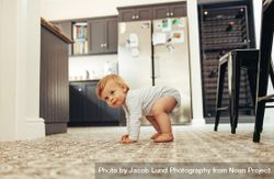 Developing child standing up on floor at home 4BkBkb