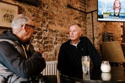 Two mature men talking over drinks at a pub 4BeYE5