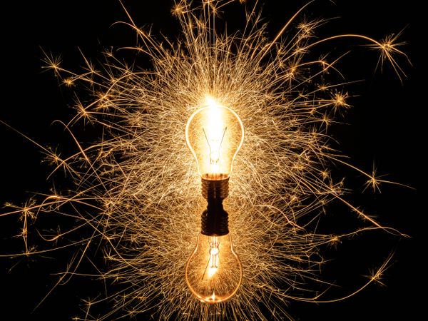 Sparkling light bulb on background