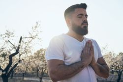 Bearded man meditating in spring garden