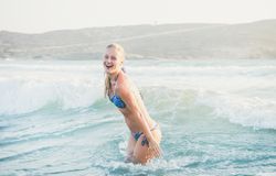 Woman in bikini smiling in the water at the beach