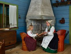 Woman showing Norwegian book to girl, at Vesterheim, Decorah, Iowa