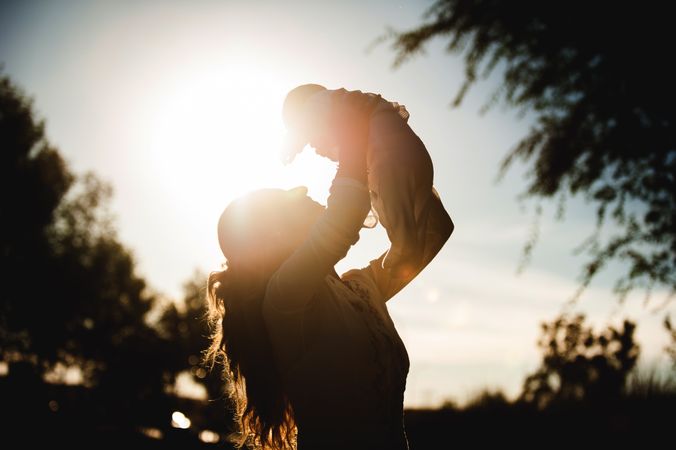 Back lit of a baby being held by his grandmother