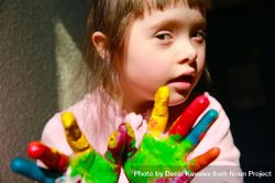 Cute young girl holding painted hands out to camera 5z9Vn0
