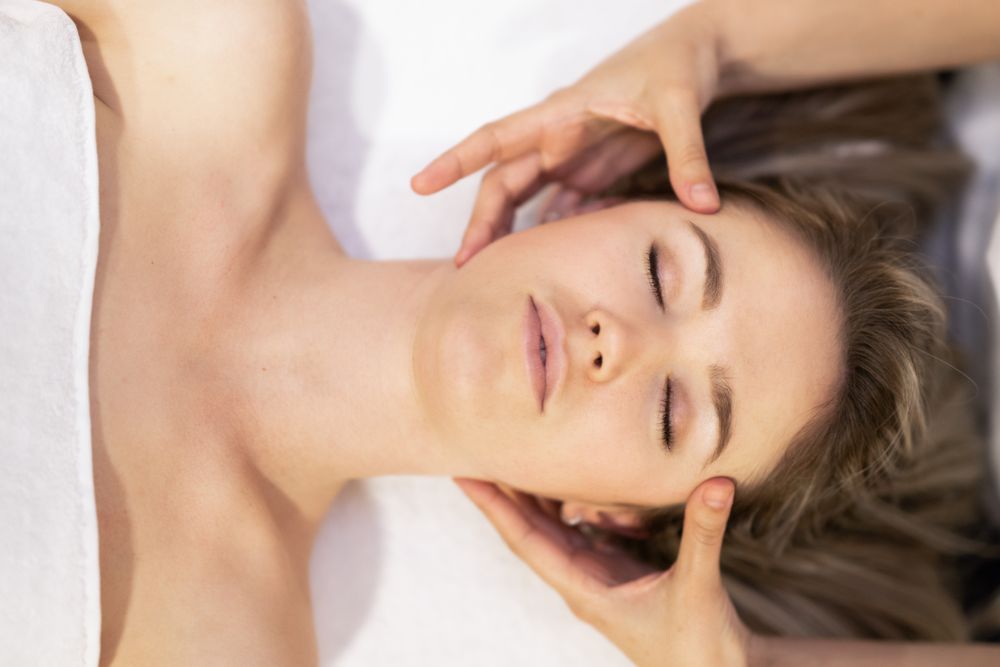 Blonde woman receiving a head massage in a spa center