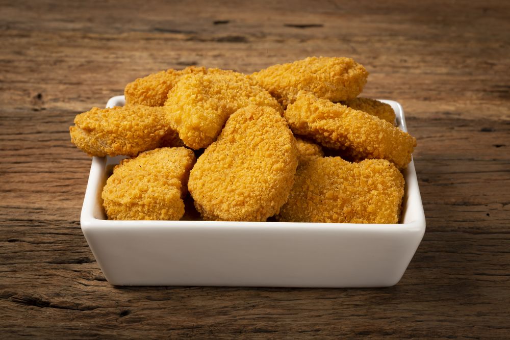 Fried chicken nuggets with ketchp and rose sauce.