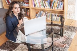 Woman relaxing with coffee and laptop