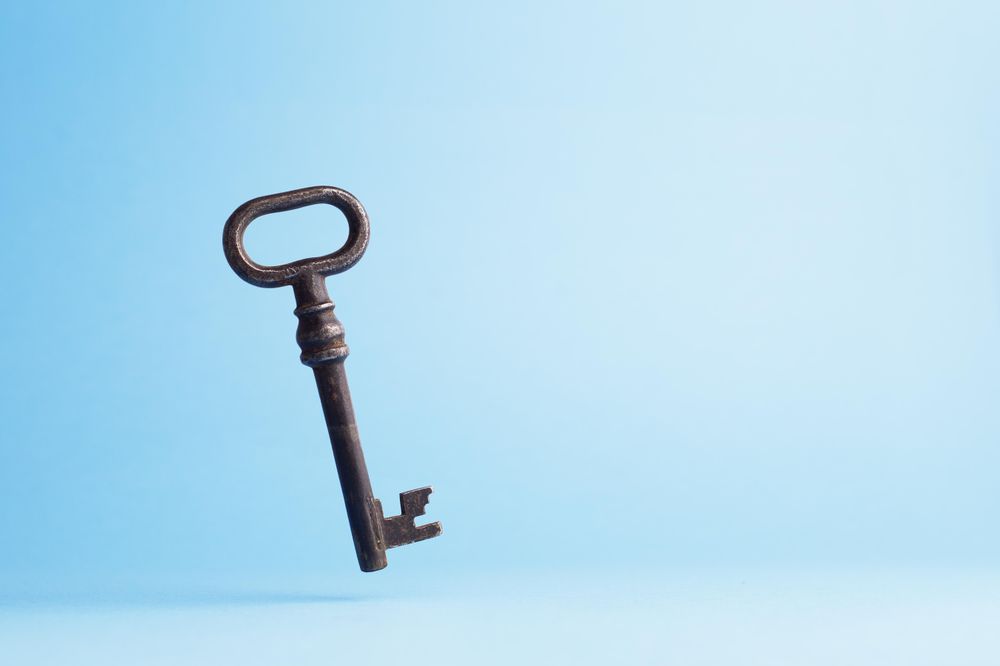 Vintage key falling over blue background