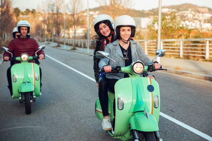 Young people riding motorcycles on city road