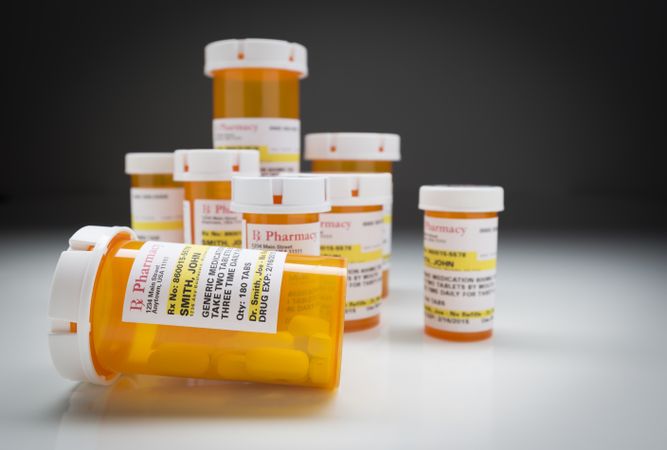 Medicine Bottles on Reflective Surface and Grey Background