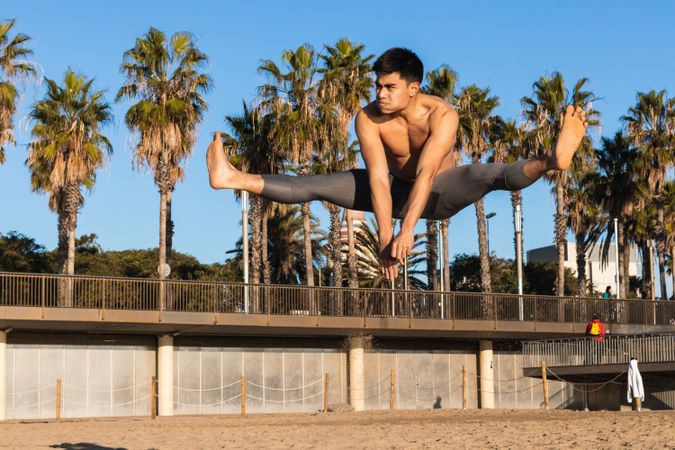 Strong man jumping high during outdoor workout