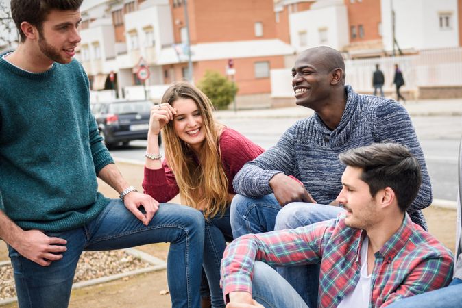 Male and female friends laughing and smiling together in city