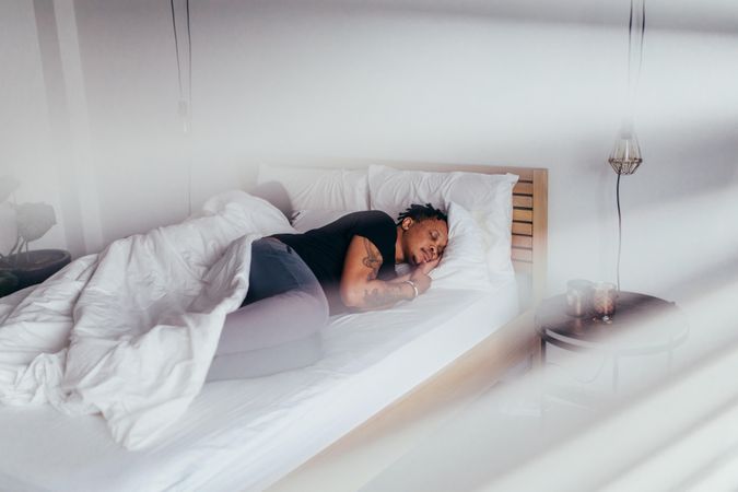 Man sleeping in bedroom with woman at back