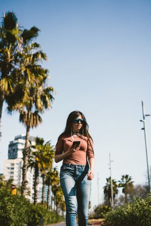 Teen girl walking happily through the streets.
