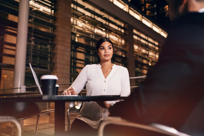 Businesswoman sitting at cafe table with businessman
